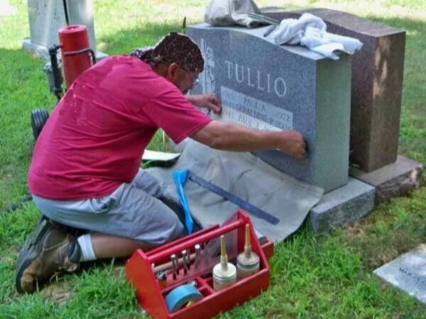 Close-up of hand-carved cemetery lettering on granite