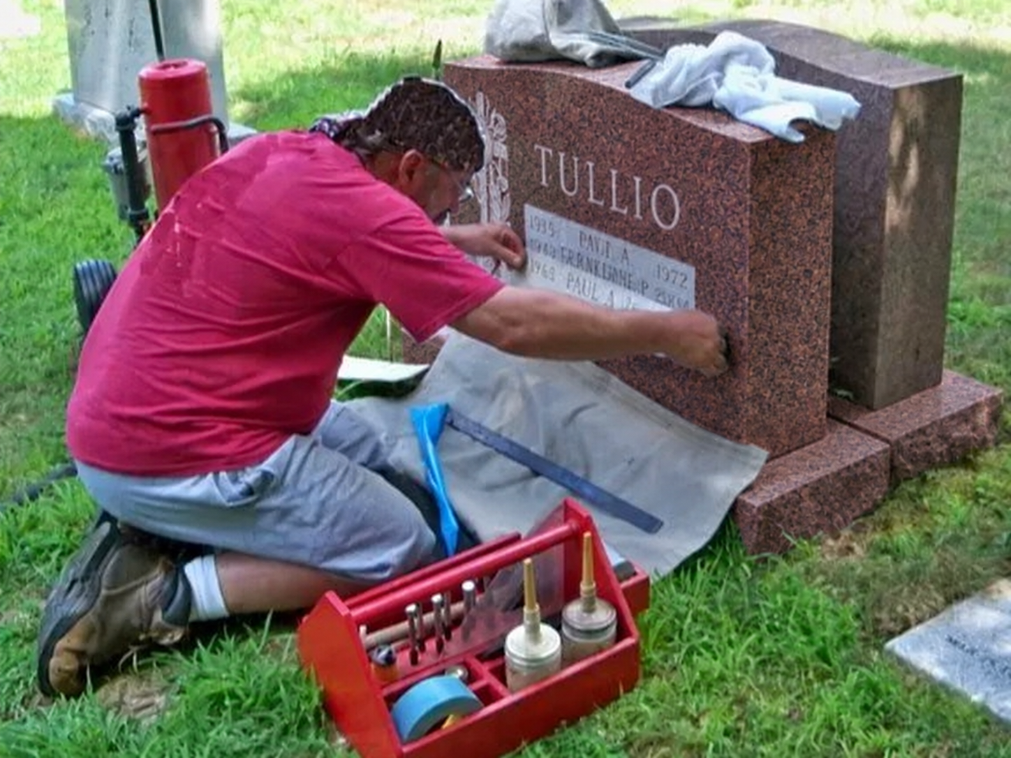 Craftsman lettering a granite headstone, shown in a mahogany color